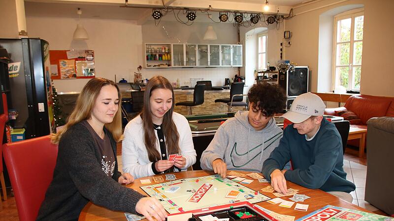 Erzieherin Annalina Hofmann (von links) und Pädagogin Eva Vieres spielen mit den Jugendlichen Adam Chlihi und Tobias Macht Monopoly. Erzieherin Annalina Hofmann (von links) und Pädagogin Eva Vieres spielen mit den Jugendlichen Adam Chlihi und Tobias Macht Monopoly.