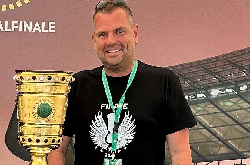 Unser Bild zeigt Eintracht Frankfurt-Fan Anton Schick mit einer Replik des DFB-Pokals vor dem Berliner Olympiastadion. Das Original sollte sp&auml;ter aus Sicht des Bad Kissinger Unternehmers der &bdquo;falsche&ldquo; Verein in die H&ouml;he stemmen.