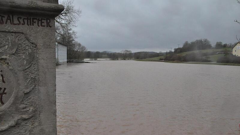 Blick von der Barockbrücke in Frickendorf Richtung Bramburg, dem Schloßberg. Vorn das braune Wasser der Baunach