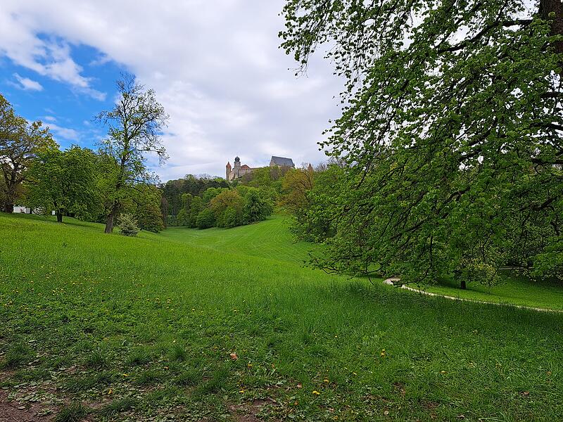 Der Hofgarten hat viele B&auml;nke. Doch f&uuml;r diese lohnt sich der Weg in Richtung Veste allemal. Von dieser, etwas versteckten Bank, hat man einen fantastischen Blick auf das Wahrzeichen.