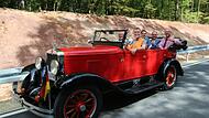 Oldtimerfan Uwe Schmidt (vorne rechts) ist stolz auf seinen fast hundert Jahren alten Chevrolet Open Tourer (Baujahr 1925). Zur Eröffnung fuhr der Seßlacher den neuen Straßenabschnitt mit Projektleiter Patrick Mohr (vorn) sowie Hans-Peter Jander (...