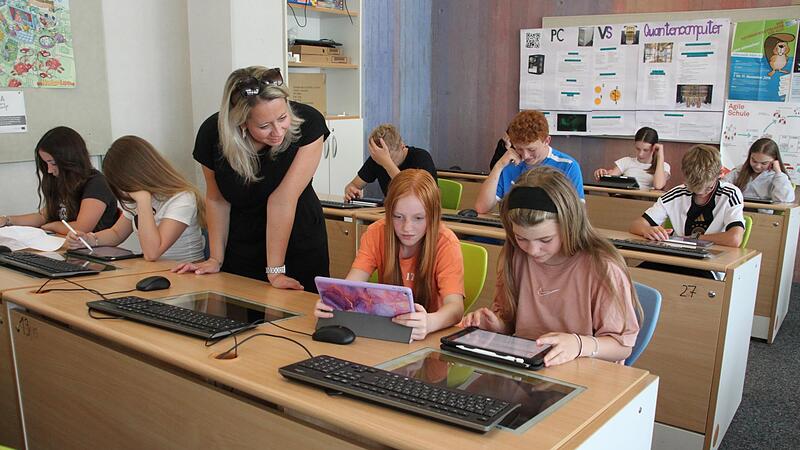 Lehrerin Christina Schott schaut den Sch&uuml;lerinnen Lisa Weber (rechts) und Hanna Zimmermann aus der Klasse 6b bei der Arbeit mit ihrem Tablet &uuml;ber die Schulter. Die Lehrerin wurde f&uuml;r ihre vorbildliche medienp&auml;dagogische Arbeit geehrt.