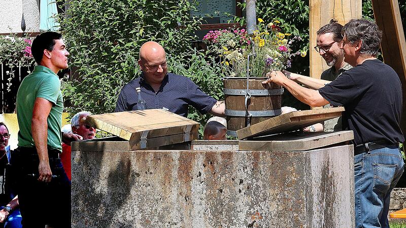 Blumen statt Wasser f&ouml;rderten (von links) Ortsreferent Oliver Jurk, B&uuml;rgermeister Michael Kastl, Kulturmanager Nicolas Zenzen und Gerrit Himmelsbach, Projektleiter des Arch&auml;ologischen Spessart-Projekts, aus dem Brunnen am &bdquo;Eck&ldquo; in Kleinwenkheim zu...
