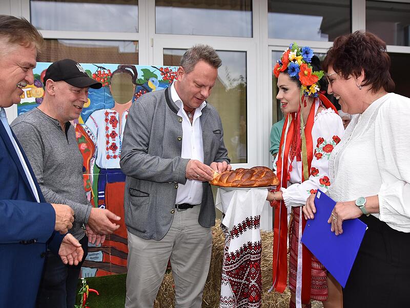 Landrat Klaus Peter Söllner, Stadtrat Matthias Hahn und OB Ingo Lehmann durften als Erste von dem Karavaj (traditionelles ukrainisches Hefebrot) probieren, das Olesya Nytka in ihrer Tracht präsentierte; mit im Bild Maria Maier (von links).