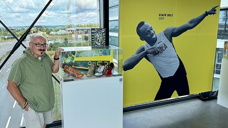 Helmut Fischer h&uuml;tet die Ausr&uuml;stung des Ausnahmeweltmeisters Usain Bolt wie signierte Laufschuhe in der Puma-Zentrale in Herzogenaurach. Bolt ist auf dem Plakat zu sehen.