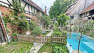 Eine gelungene Restaurierung: der idyllische Dreiseithof von Annika Berg in Go&szlig;mannsdorf, wo Rosen und Staudenbeete die alte Hofstelle verzaubern.