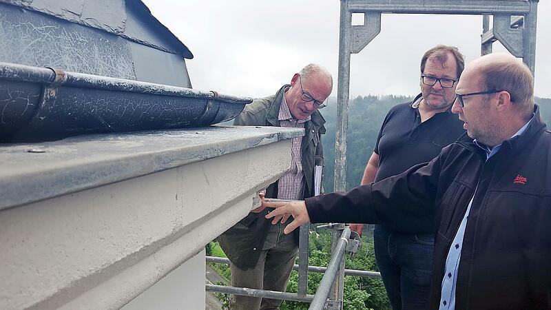 In luftiger H&ouml;he begutachten (von links) die Architekten Peter Kropf und Sandro Selig sowie Kirchenpfleger Bernd Peter die Sch&auml;den an der Au&szlig;enfassade der Kirche.