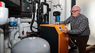 Franz Dirauf zeigt das Herzst&uuml;ck der Heizanlage, die W&auml;rmepumpe.