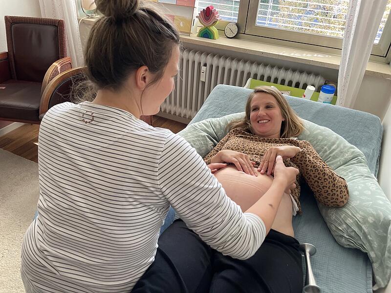 Franziska Se&szlig;ler (r.) hat sich zum zweiten Mal f&uuml;r eine Geburt im Geburtshaus in Erlangen entschieden. Hebamme Julia Baecker (l.) untersucht den Babybauch.