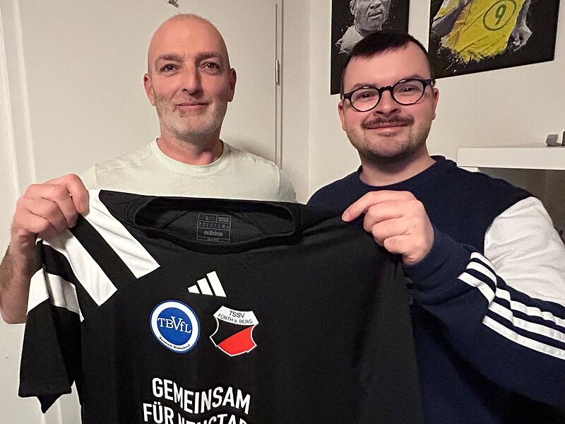 Matthias Oehrl, Sportlicher Leiter der TSSV F&uuml;rth am Berg (links) und Matthias Friedrich, sein Amtskollege beim TBVfL Neustadt/Wildenheid halten das erste frischbedruckte Trikot der geplanten Spielgemeinschaft in H&auml;nden. Die Fu&szlig;baller aus F&uuml;rth am Berg und Wildenheid wollen ab der Saison 2026/2027 mit insgesamt drei Mannschaften gemeinsam auf Torejagd gehen.