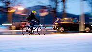 Ein Fahradfahrer auf einer verschneiten Stra&szlig;e im Winter