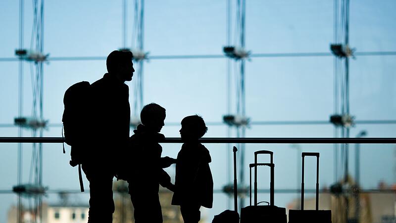 Familie steht mit Gep&auml;ck am Bahnhof