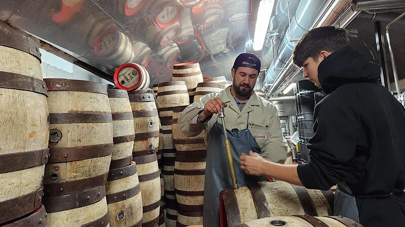 Brauer  Mark   Böhm zeigt seinem Praktikanten Jaurel Juteau, wie die Holzfässer für das Abfüllen mit Aecht Schlenkerla Rauchbier vorbereitet werden. Die eigene Gastwirtschaft versorgt das Schlenkerla in Bamberg mit Holzfässern.