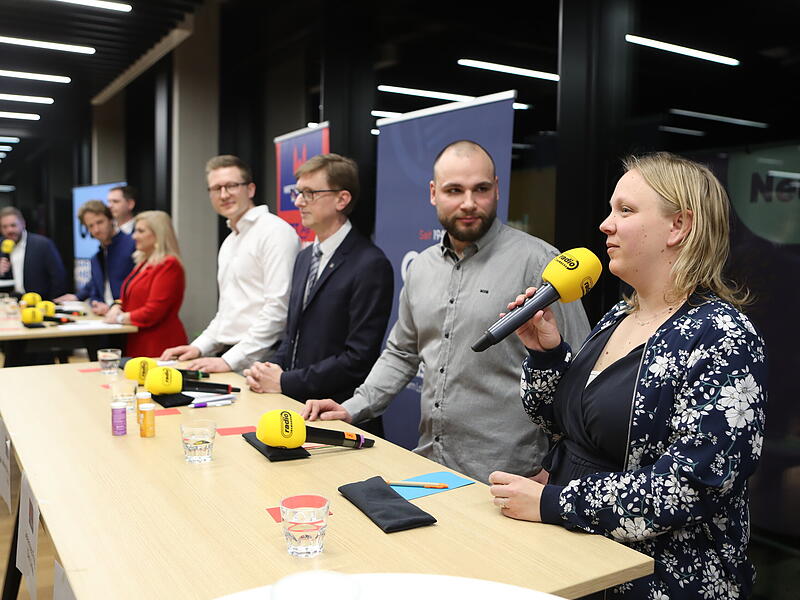 Claudia John (Freie W&auml;hler, von rechts) im Gespr&auml;ch mit Johannes Frey (Die Linke), Hans-G&uuml;nter Br&uuml;nker (Volt), Ralf St&ouml;cklein (FDP), Melanie Huml (CSU), Sebastian Niedermaier (SPD) und Jonas Gl&uuml;senkamp (Gr&uuml;ne) bei der PodiumsdiskussionPodiumsdiskussion OB-Wahl