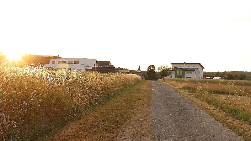 Links des Weges entsteht das Neubaugebiet &bdquo;Zum Stolzenrangen&ldquo; in Reutersbrunn. Im Hintergrund der Ort mit Kirche.