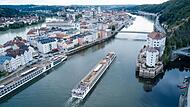 Ein Flusskreuzfahrtschiff fährt stromaufwärts an Passau vorbei