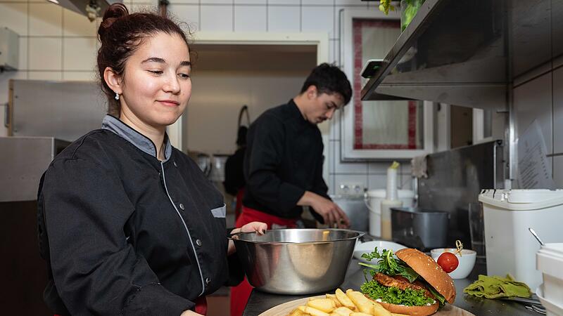 Leandro Gebhardt und Farangis Haqnazarova, haben eine Platte mit Burger und Pommes garniert.1326129 Leandro Gebhardt und Farangis Haqnazarova, haben eine Platte mit Burger und Pommes garniert.1326129