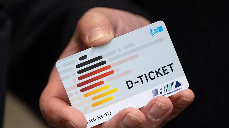 Eine Hand h&auml;lt ein Deutschlandticket.