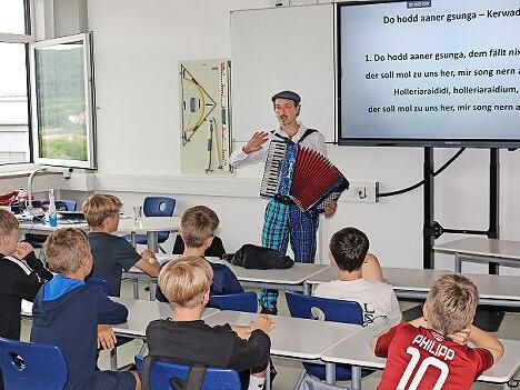 David Saam übt mit den Schülern das Kerwaliedersingen.