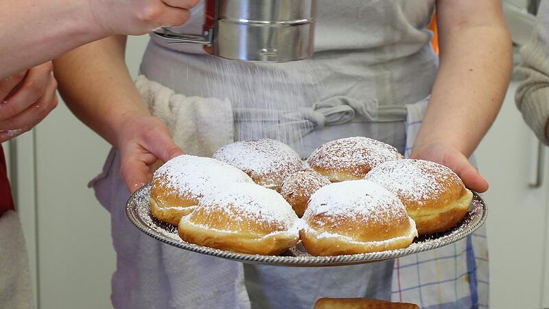 Die fertigen Krapfen werden mit Marmelade gef&uuml;llt und mit Puderzucker best&auml;ubt.