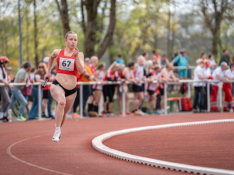 Eine Teilnehmerin des 4x400 m-Staffelwettbewerbs der Frauen l&auml;uft vor einer gro&szlig;en Zuschauerkulisse.