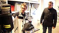 Der Atemschutzbeauftragte der Feuerwehren in Untersiemau, Dirk Engel, erklärt Bürgermeister Rolf Rosenbauer und den Bauausschussmitgliedern die Funktionsweise eines Atemschutzgerätes.