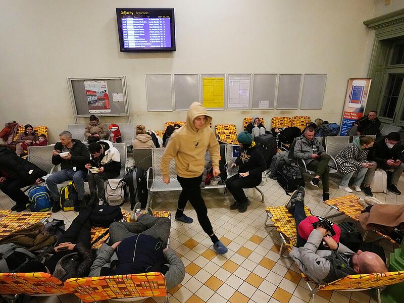 Menschen aus der benachbarten Ukraine ruhen sich in einer Bahnhofshalle aus, die in ein Unterkunftszentrum in Przemysl, Polen, umgewandelt wurde. Russland hat am Donnerstag, 24.02.2022, den Angriff auf die Ukraine gestartet, während Zivilisten in Züge und Autos stiegen, um zu fliehen.