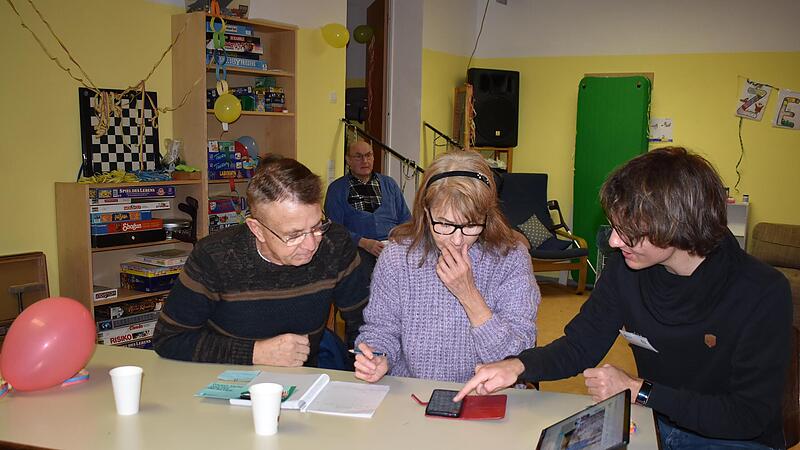 Das Ehepaar Karl-Heinz und Hasibe Dudeck ist aus der Nachbargemeinde Eckental nach Igensdorf gekommen und lässt sich vom „digitalen Engel“ Johannes Diller (r.) aus Köln den richtigen Umgang mit dem Smartphone zeigen.Forchheim & Fränkische Schweiz Das Ehepaar Karl-Heinz und Hasibe Dudeck ist aus der Nachbargemeinde Eckental nach Igensdorf gekommen und lässt sich vom „digitalen Engel“ Johannes Diller (r.) aus Köln den richtigen Umgang mit dem Smartphone zeigen.Forchheim & Fränkische Schweiz