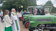 Pfarrer Bernhard Öchsner beim Segnen der Oldtimer-Traktoren und ihrer Fahrer.