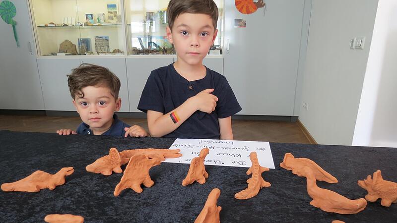 Mateo und Lias begutachten  die Urzeittiere aus Ton.