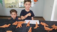Mateo und Lias begutachten  die Urzeittiere aus Ton.
