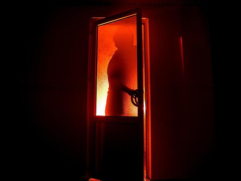 Neunkirchen am Brand: Einbrecher überrascht Ehepaar im Schlafzimmer bedrohlich, einbrecher, türe, Silhouette einer unbekannten Schattenfigur an einer Tür durch eine geschlossene Glastür. Die Silhouette eines Menschen vor einem Fenster in der Nacht. Scary Szene Halloween Konzept der unscharfen Silhouette von Maniac.