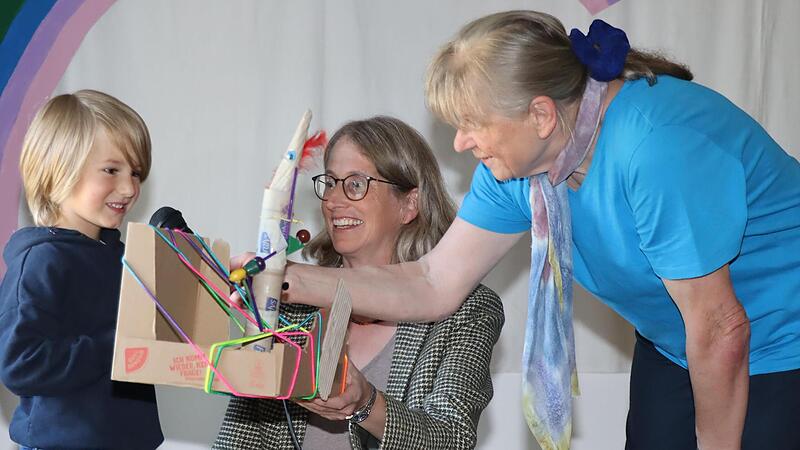 Martteo zeigt und erkl&auml;rt Projektleiterin Ingrid Nolting und Kita-Leiterin Elfie Bienlein (v. links) eine gebastelte Rakete.