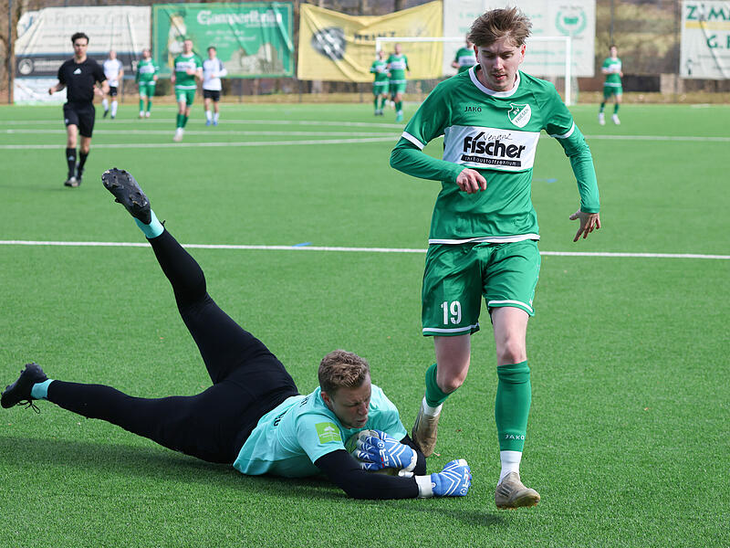 Der M&uuml;nchberger Keeper Jonas Lang ist rechtzeitig aus seinem Kasten und holt sich den Ball vor dem Friesener Leon Jakob.