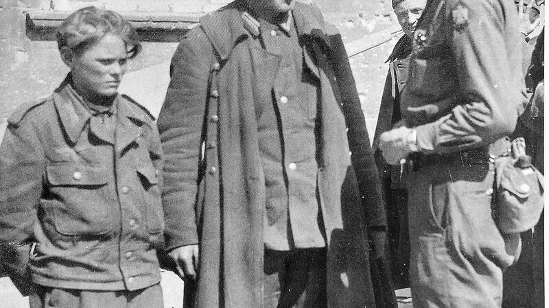 Ein amerikanischer Soldat spricht mit Angeh&ouml;rigen des Volkssturms.  Fotos: Repro Franze, aus: Karl Kunze "Kriegsende in Franken und der Kampf um N&uuml;rnberg"