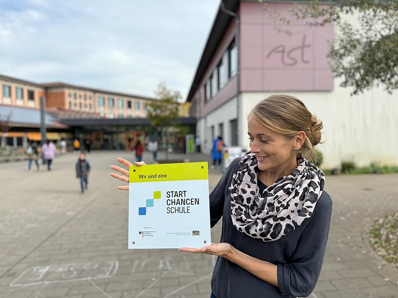 Stolz pr&auml;sentiert Konrektorin Karin Van Gompel die Startchancen-Plakette der AST