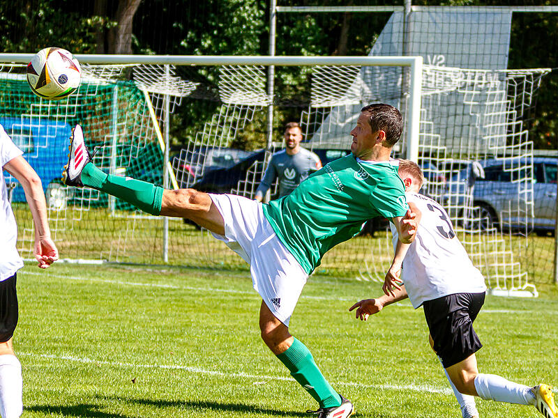 Mit dem hohen Bein versucht der Katschenreuther Mathias Weigel den Ball zu erreichen, während der Katschenreuther Abwehrspieler Fabian Heer dahinter lauert.