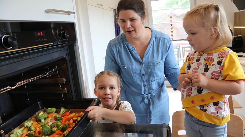 Ella schiebt das Ofengem&uuml;se in den Backofen. Mama Sandra Karl passt auf. Gekocht haben sie nach der neuen Rezeptesammlung aus dem Kindergarten &bdquo;Kleine Welt&ldquo;.