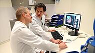 Prof. Dr. Felix Gundling und sein Kollege Prof. Dr. Georg Pistorius schauen sich die endoskopische Aufnahme eines Patienten an, um gemeinsam zu entscheiden, ob eine Operation notwendig ist.