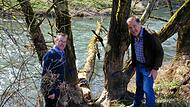 Edgar Thomas (links) und Albrecht Leurer inspizieren  eine Gefahrenstelle in der Saale. Hier blockiert ein umgefallener Baum den Strom.