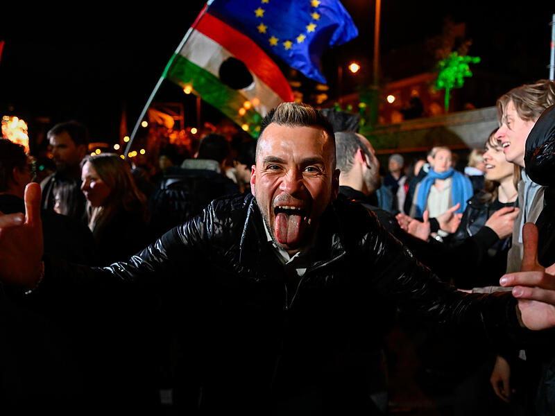 12.04.2026, Ungarn, Budapest: Ein Mann feiert auf der Stra&szlig;e nach der Bekanntgabe der Teilergebnisse bei der Parlamentswahl. Foto: Denes Erdos/AP/dpa +++ dpa-Bildfunk +++