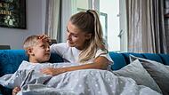 Eine Mutter k&uuml;mmert sich um ihr kranken Kind mit Fieber