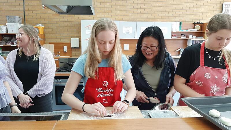Kursleiterin Li-Lin Hummitzsch zeigt den Teilnehmern des Sushi-Kochkurses die Handgriffe.