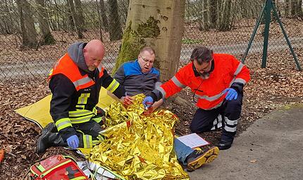 Ernstfall im Freien: Zwei Teilnehmer der Abschlusspr&uuml;fung versorgen einen Verletzten mit Rettungsdecke und Verbandsmaterial, eine von vielen realistischen &Uuml;bungsszenen beim Abschlusstag.