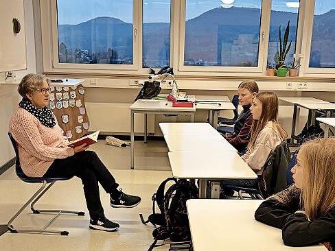 Lehrerin Heike Schwarzmann liest interessierten Schülern vor Schulbeginn vor.