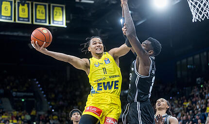 Nicholas Tischler (mit Ball) verschafft sich beim Korbabschluss Platz gegen den besten Shotblocker der Liga, EJ Onu.