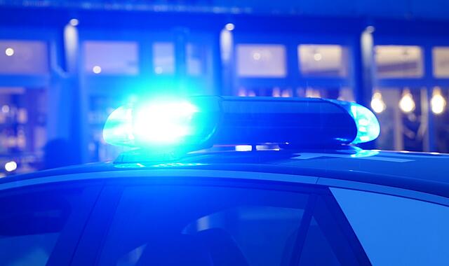 Ein Streifenwagen der Polizei mit eingeschaltetem Blaulicht Ein Streifenwagen der Polizei mit eingeschaltetem Blaulicht