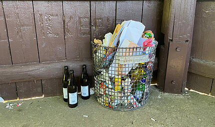 Achtsamkeit NaturForchheim & Fränkische Schweiz Ein voller Müllbehälter am Aussichtspavillon oberhalb von Heiligenstadt, der fast ausschließlich Wertstoffe wie Glas, Papier und Kunststoff enthält. Leergut wurde einfach neben dem Behälter entsorgt, der Boden ist voller Zigarettenkippen.