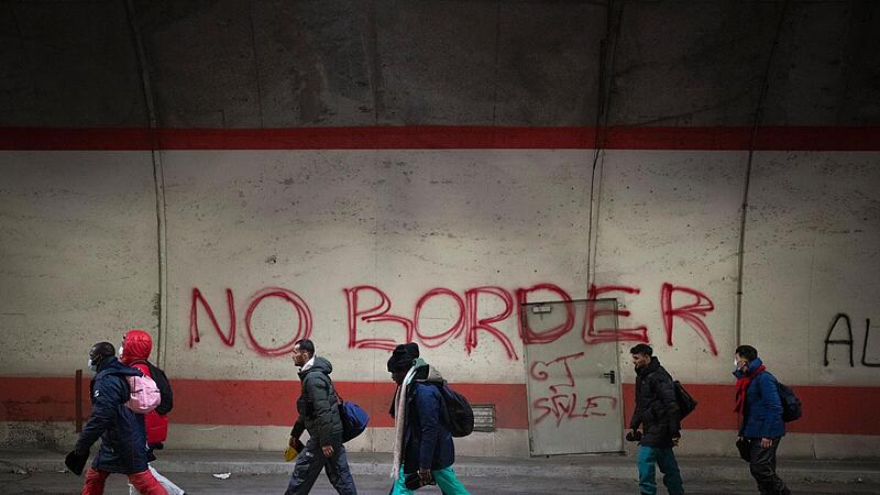 Migranten, die auf dem Weg von Italien nach Frankreich sind, gehen an einem Graffiti mit der Aufschrift „No Border“ (dt. Keine Grenze) in einem Tunnel vorbei, der zur französisch-italienischen Grenze führt. Migranten, die auf dem Weg von Italien nach Frankreich sind, gehen an einem Graffiti mit der Aufschrift „No Border“ (dt. Keine Grenze) in einem Tunnel vorbei, der zur französisch-italienischen Grenze führt.