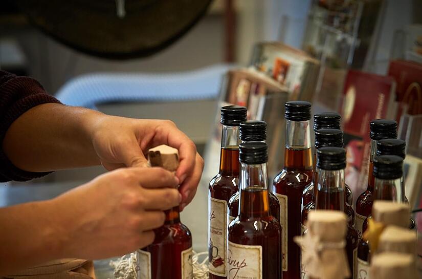 Die Sirupe werden bei Schusters Spezialitäten weihnachtlich dekoriert.